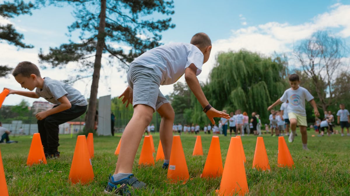 Group of kids enjoying exercise and play at a park obstacle course.